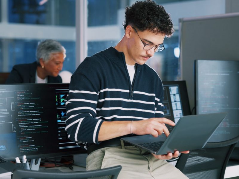 Man, programmer and office with laptop for coding, software development or app design. Male person, coder or developer with computer or technology for cybersecurity, web or IT services at workplace Man, programmer and office with laptop for coding, software development or app design. Male person, coder or developer with computer or technology for cybersecurity, web or IT services at workplace.