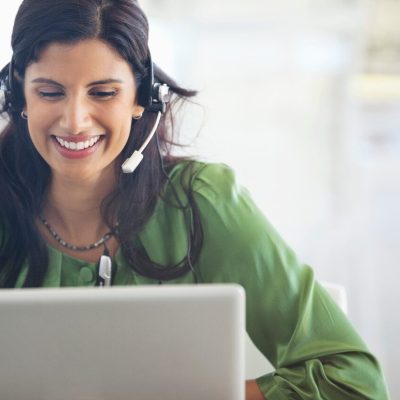 Businesswoman wearing headset at desk